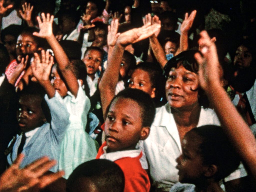 Crowd of black women and children raising their hand