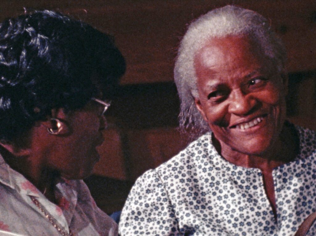 Two black women facing each other and speaking