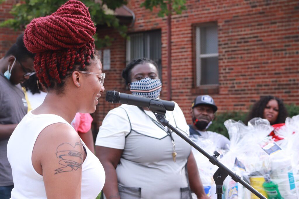 Woman speaking into a microphone at an outdoor event