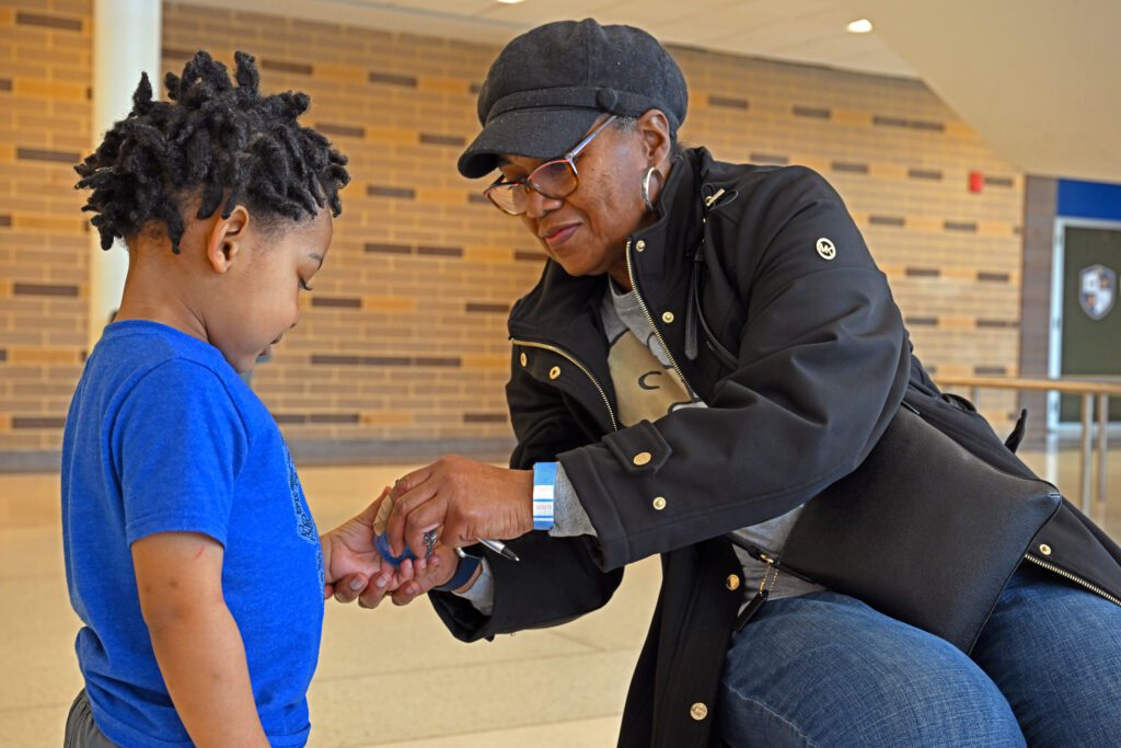 Woman placing something in the hand of a young boy