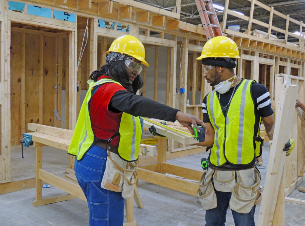 two black workers in hard hats on a construction site