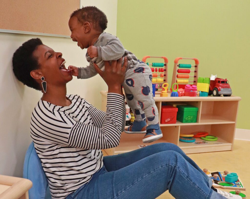 Woman lifting baby up playfully