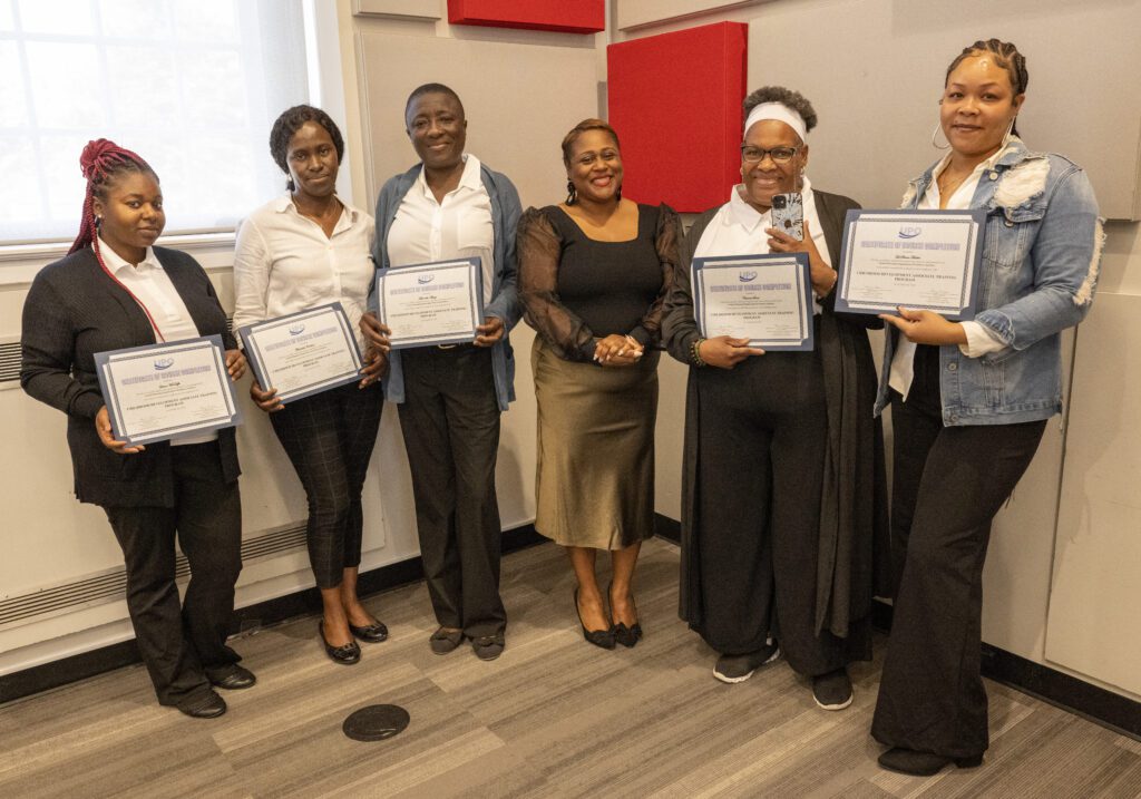 Group of women holding up their certificate from the childhood development associate training program with their teacher